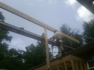 Carpenter setting a ridge beam over a new addition frame — Ice Dam Removal by Roofing Brothers in Dalzell