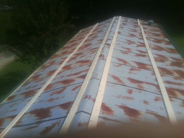 Rusted metal roof panels with new wood purlins before replacement — Storm Damage Roof Repair in Dalzell by Roofing Brothers