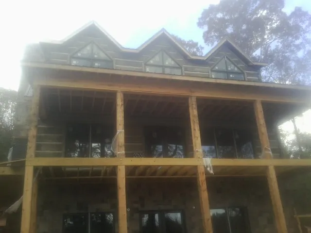 Dormers and porch framing on a large log home under construction — Roof Coating work by our crew in Dalzell