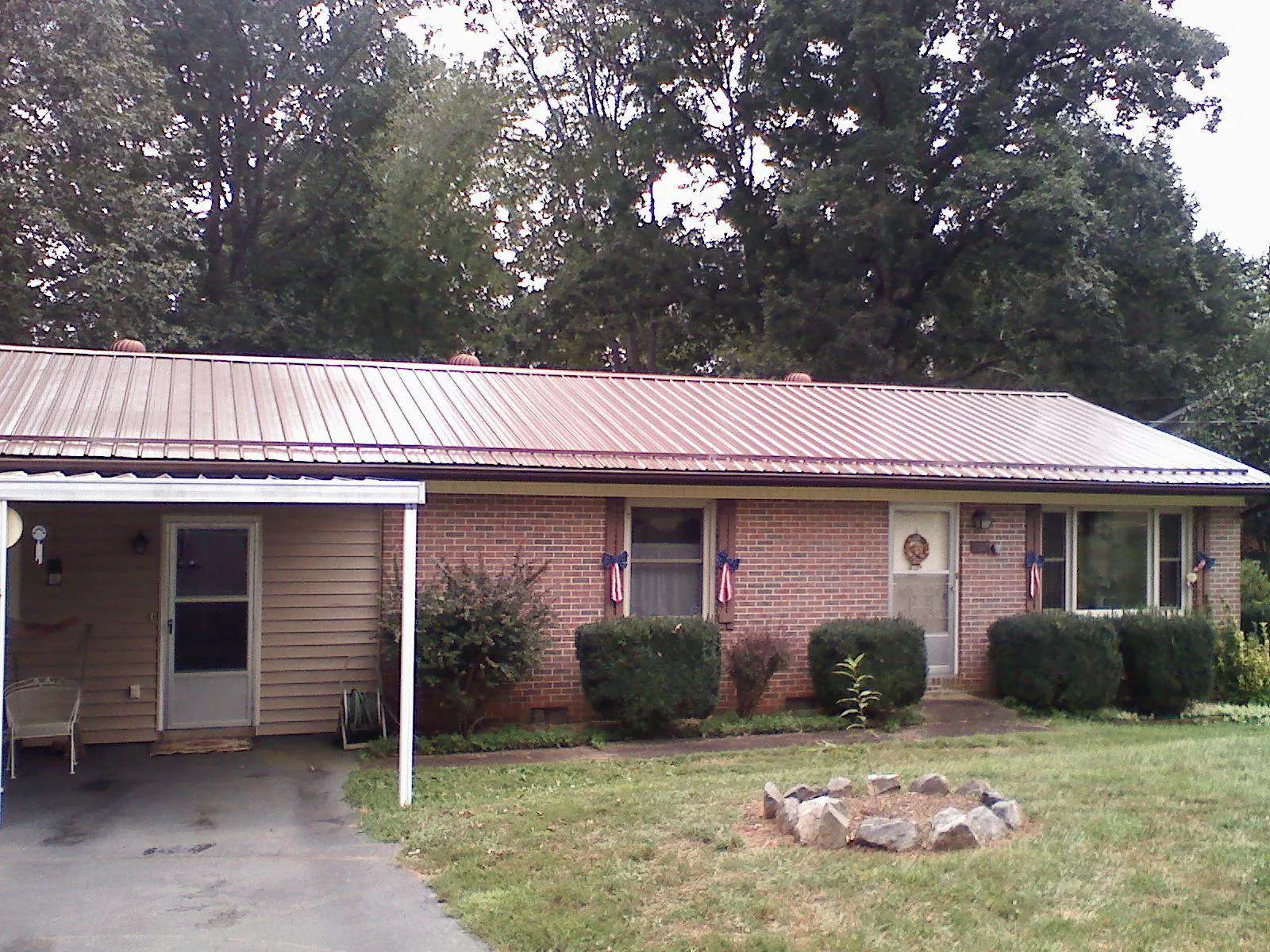 Bronze metal roof and carport on a brick ranch home — Roof Repair work by our crew in Dalzell